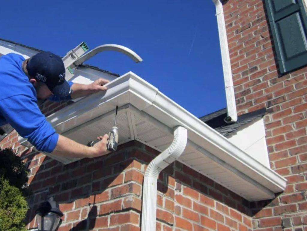 Close-up of seamless aluminum gutter with downspout properly directing water away from home foundation
